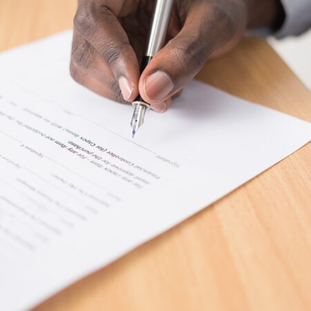 Close up of a person signing a document