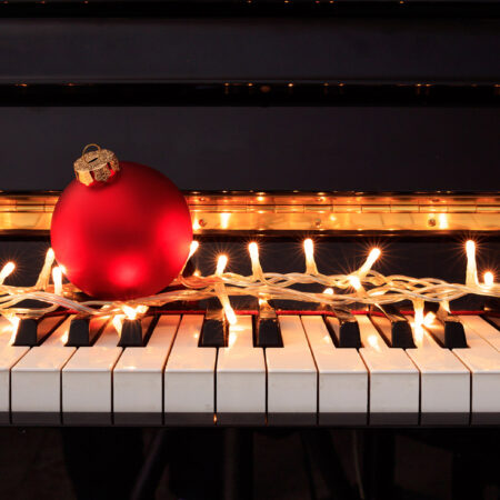 Christmas ball and lights on a piano keyboard