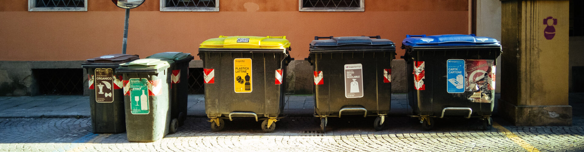 Trash bins lined up against brick building