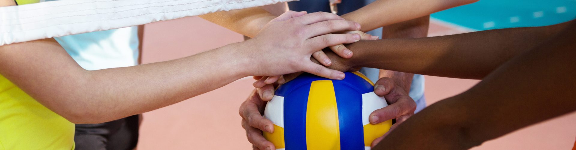 Close-up of player's hands holding volleyball together
